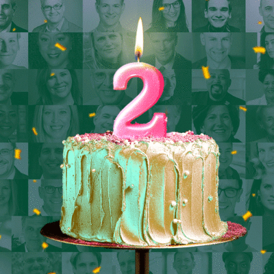 A frosted cake with a number 2 candle is surrounded by a collage of grayscale headshots in the background.