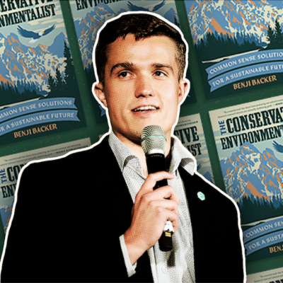 Person holding a microphone in front of a background featuring multiple covers of the book "The Conservative Environmentalist.