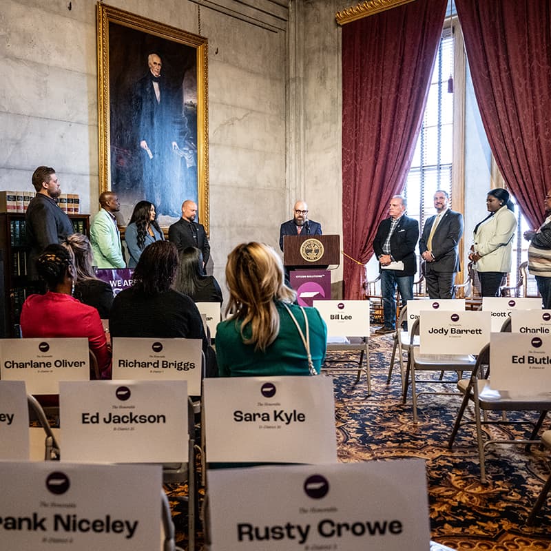 A group of citizens standing on either side of a lectern in a legislative building in Tennessee.