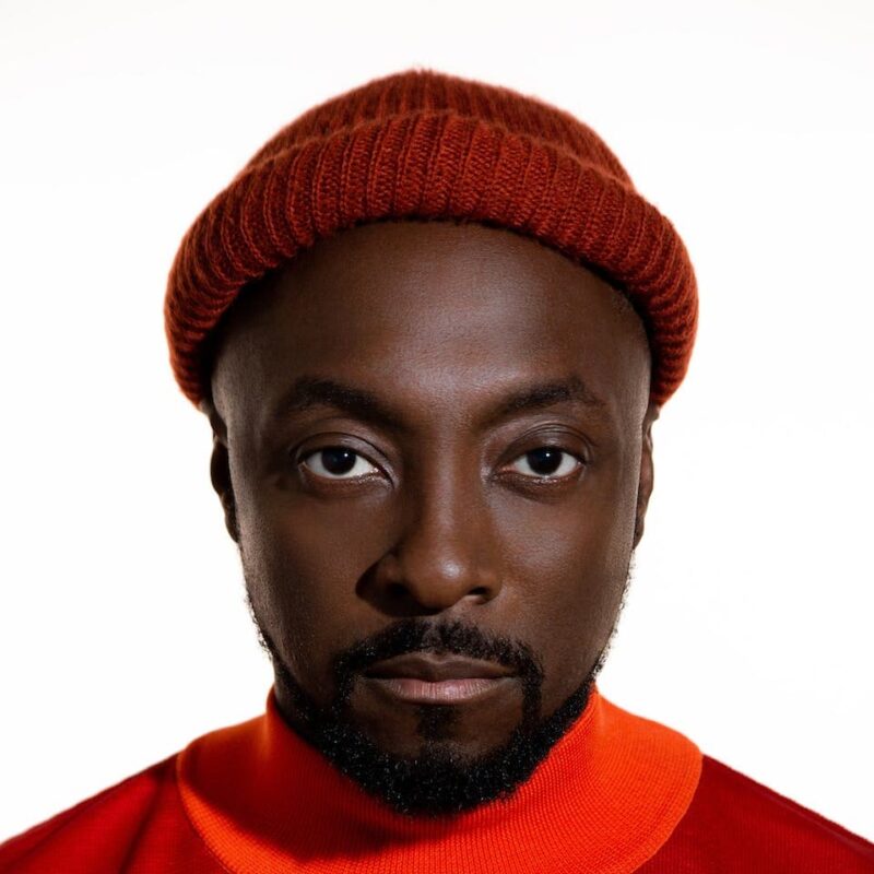 Person wearing a red beanie and orange shirt, looking directly at the camera against a white background.