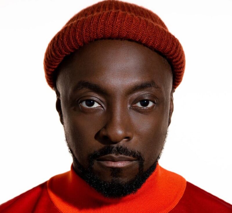 Person wearing a red beanie and orange shirt, looking directly at the camera against a white background.